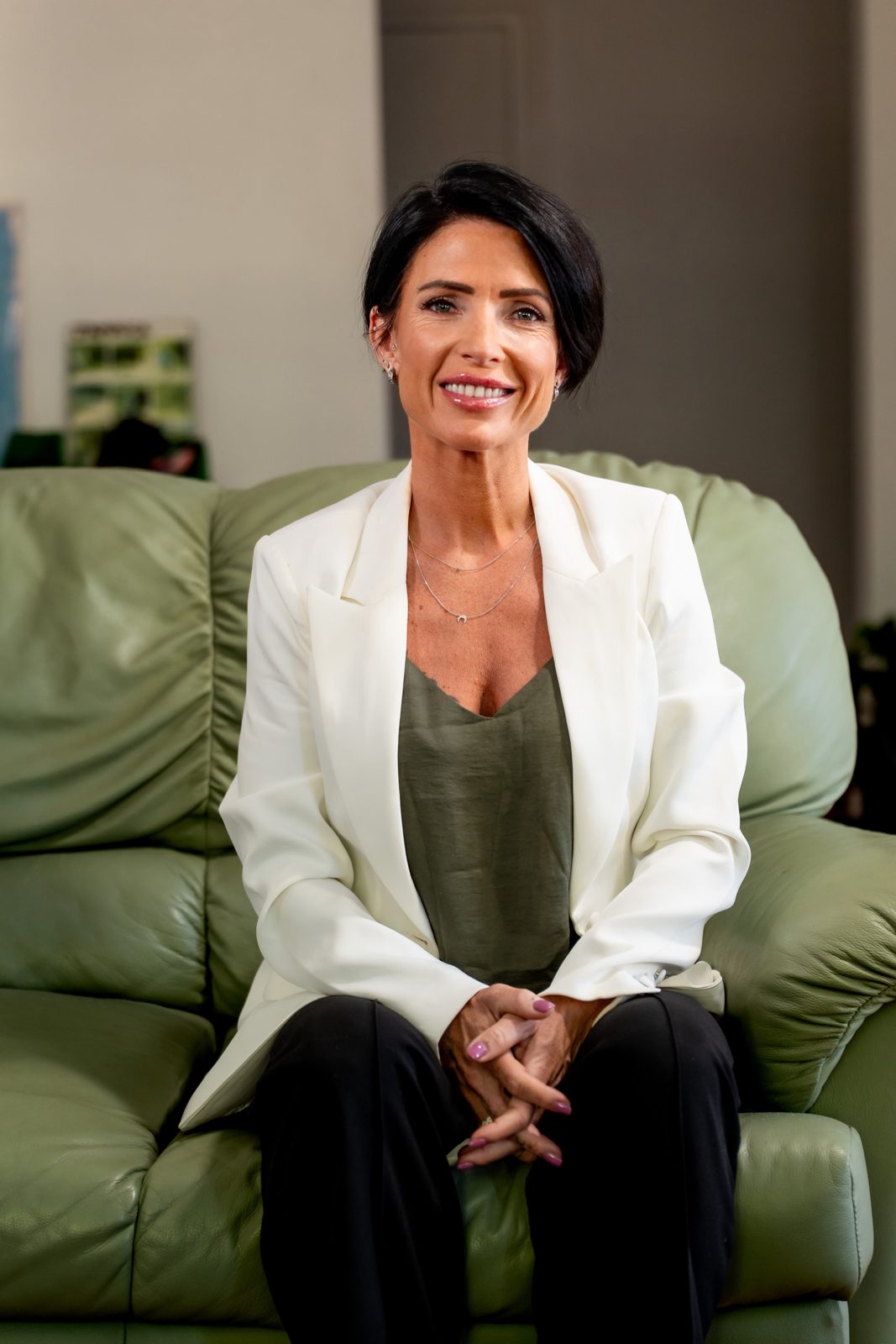 Indi seated on a green sofa